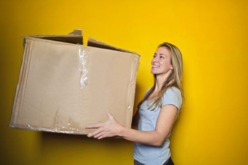 Woman in Grey Shirt Holding CardBoard Things You Need to Know About Shipping on eBay